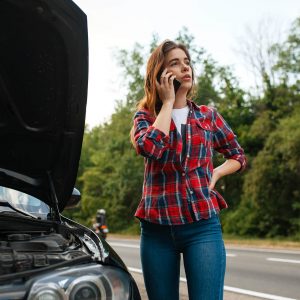 woman-calling-a-tow-truck-on-road-car-breakdown-VA6END5.jpg